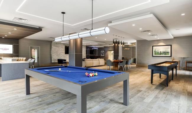 a room with a pool table and chairs