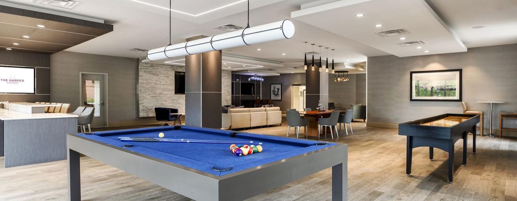 a room with a pool table and chairs
